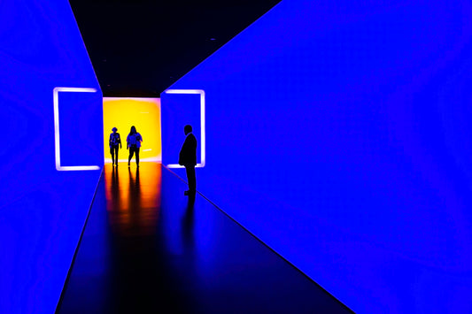 three person standing near wall inside building
